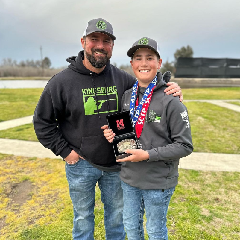 Father and son with champion belt buckle